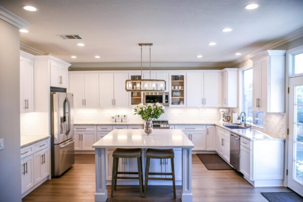 Spacious kitchen featuring white cabinetry, an island with seating, and stainless steel appliances